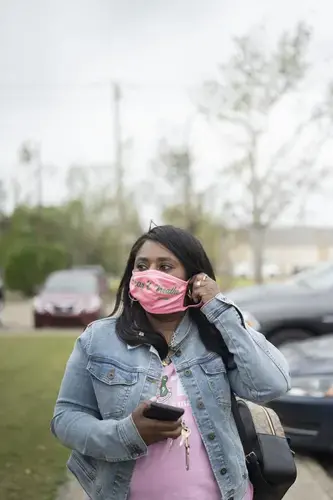 Founder of Lake Charles Black Business Owners Tasha Guidry, who is leading local voter education amidst a pandemic and two back-to-back hurricanes, puts her face mask on before entering the SWLA Center for Health Services. Image&nbsp;by Katie Sikora. United States, 2020.