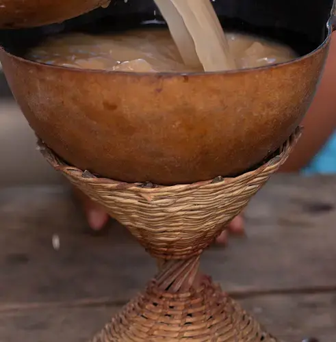 Pouring the traditional guaraná drink consumed whenever a Sateré group meets to reach consensus. The debate itself is known as çapó. Image by Matheus Manfredini. Brazil, 2019.