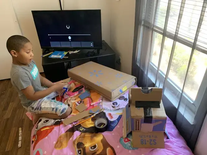 Meegale Hundley tried to make a toy safe out of old cardboard boxes in his room. Image by Aisha Sultan /&nbsp;Post-Dispatch. United States, 2020.