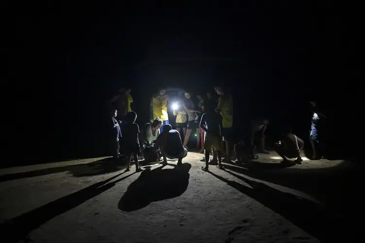 An indigenous woman tries to start a power generator. Her community has no energy service, no health care centre, a shortage of medicines and several of the children are malnourished. Image by Luis Ángel. Colombia, 2019.