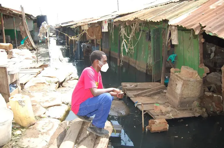 Noah Omuya looking at the flooded shop that belonged to Sarah Kaine before it was taken over by the water.&nbsp;Image courtesy of&nbsp;Noah Omuya. Uganda, 2020.