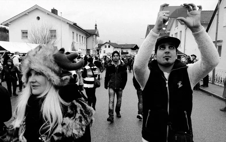 Ali Daas takes photos during Carnival in Altenmarkt, Bavaria. Image by Frank Hessenland. Germany, 2017. 