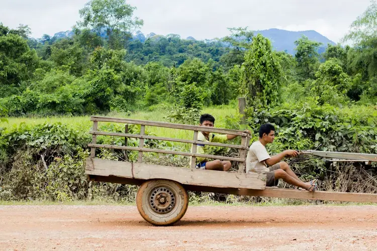 A farmer and son transport rice around the region UXO Lao is clearing. Image by Erin McGoff. Laos, 2017.