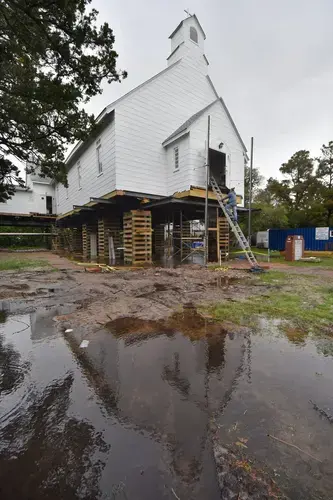 William Adams with Landmark Building and Design descends from the Ocracoke United Methodist Church on School Road where it has been elevated to accommodate storm surge after damage sustained during Hurricane Dorian in 2019. Image by&nbsp;Dylan Ray. United States, undated.