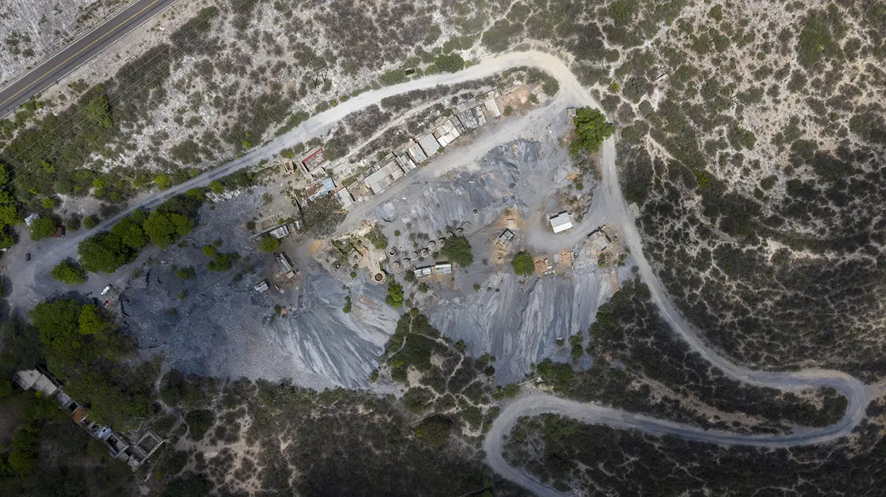 Aerial view of the mine, a cluster of shelters, and access roads.