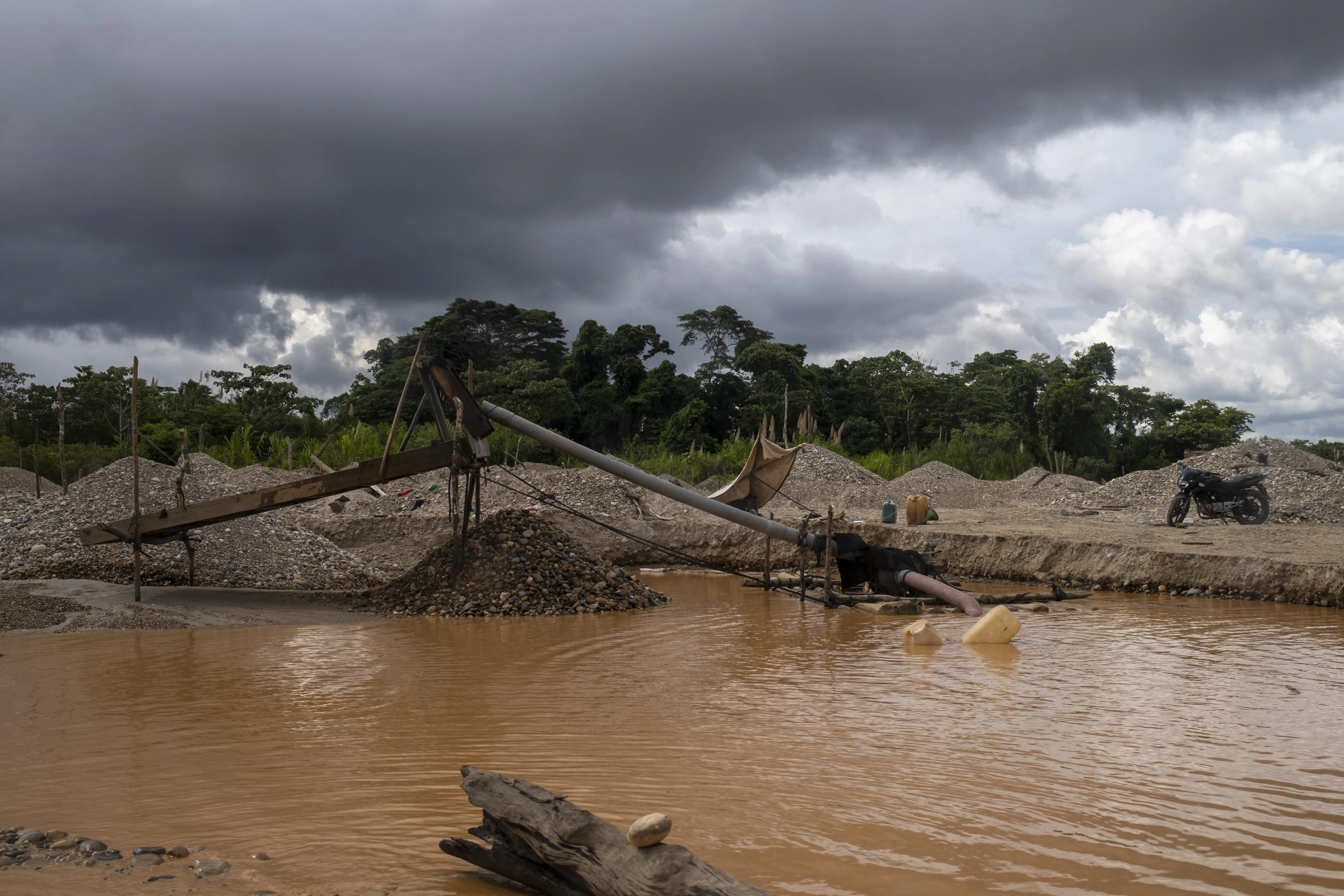 Los equipos de filtración y amalgamación forman un arco sobre las aguas turbias y los vertederos.