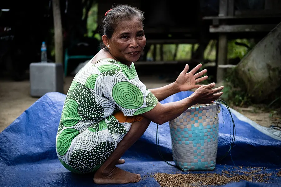 A woman is crouched over a basket 