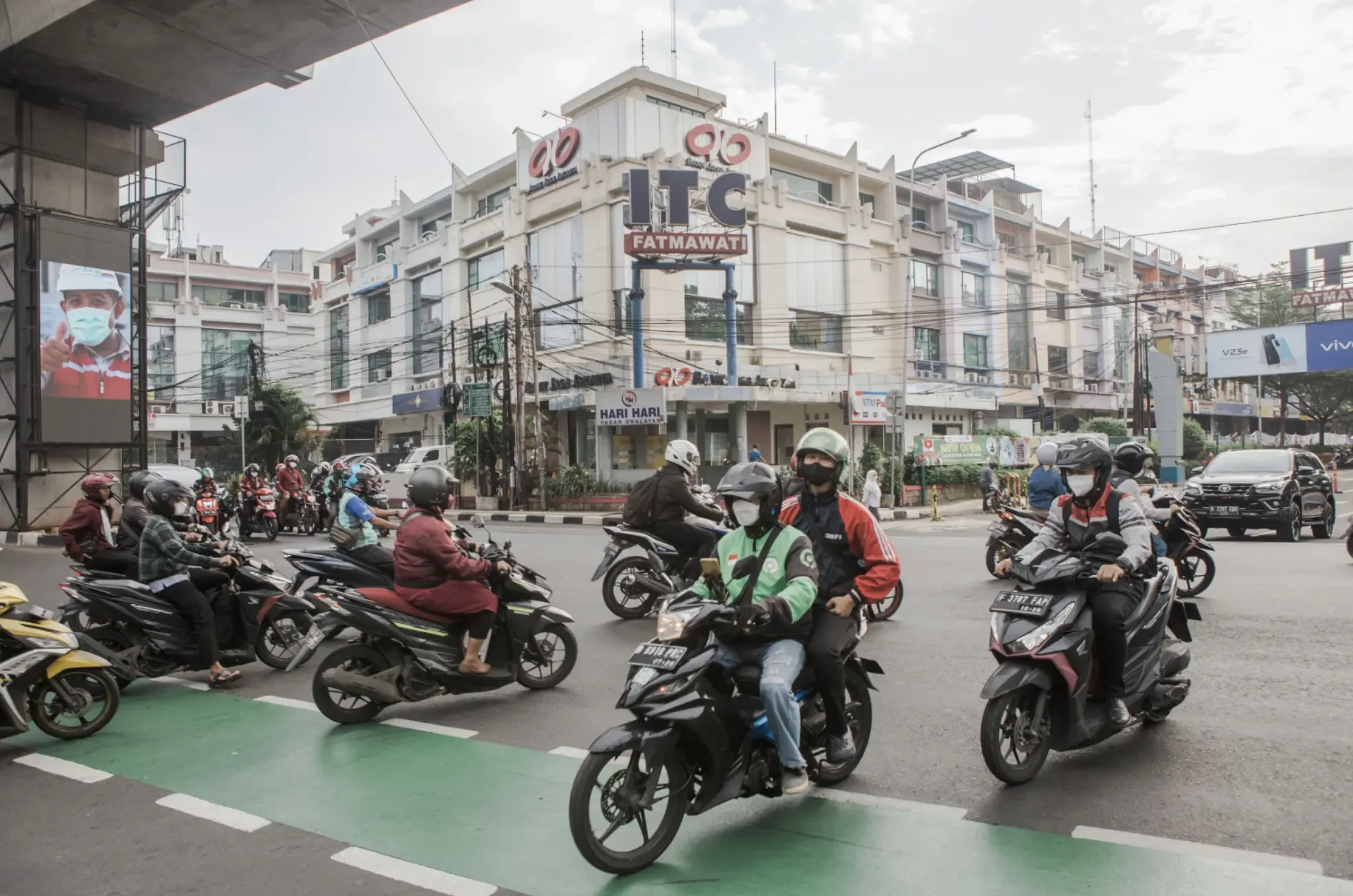 People ride through a downtown on scooters