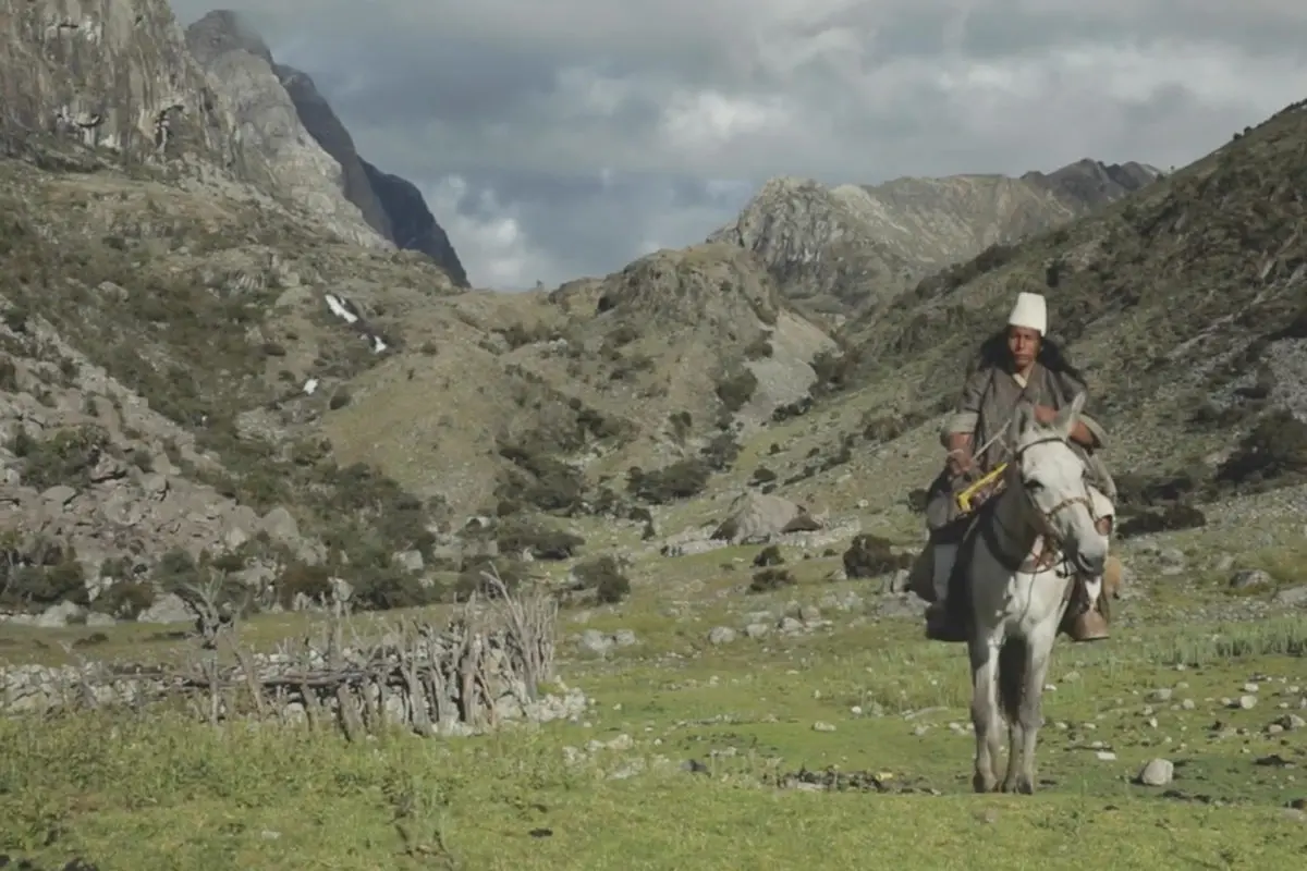 A Indigenous man rides a horse through the Sierra Nevada