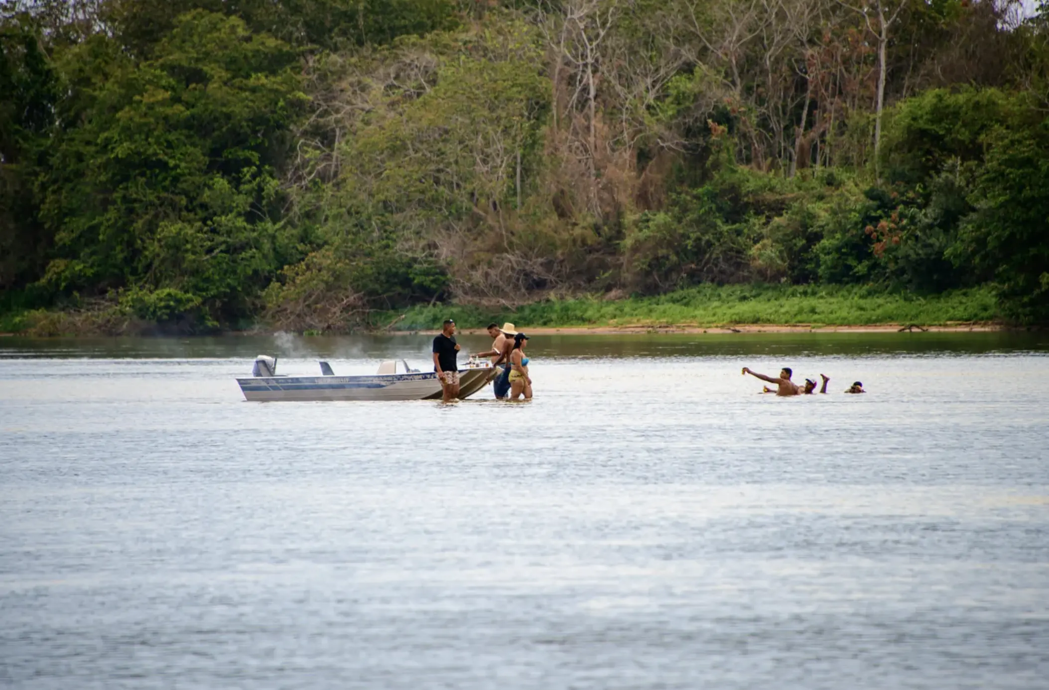 Tourists have a barbecue on the river in a motorboat
