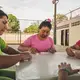 A group of prisoners playing a game of dominos in an outdoor common area in Ana Maria Campos I Prison, Maracaibo. Image by Ana María Arévalo. Venezuela, 2018.