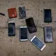 Phones and other items are placed on the ground by police officers as they inspect a boat where 15 Malians were found dead adrift in the Atlantic on Thursday, Aug. 20, 2020, in Gran Canaria island, Spain.&nbsp;Image by Emilio Morenatti/AP Photo. Spain, 2020.