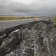 In a warming Northwest Alaska climate, maintenance costs are mounting on this 73-mile road that connects Nome to the community of Teller. Permafrost under this route is thawing, causing settling, cracking and sloughing that require more frequent repairs. Image by Steve Ringman. United States, 2019.