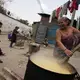 Alma Iris Garay, 50, who fled violence in El Salvador as a child, who has lost a son to drugs, beams as she stirs her vat of corn on a street corner, where the smoke from the open fire won’t choke her. She makes tortillas on a gas stove inside her home in Guatemala City. Image by Lynn Johnson. Guatemala, 2017.