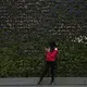 A woman stops to check her phone in front of a wall of flowers decorating The Bund, a popular tourist destination, Saturday, September, 30, 2017, in Shanghai. Image by Kelsey Kremer. China, 2017.