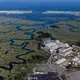The Seabrook Nuclear Generating Station, built alongside a marsh on the coast of New Hampshire, is considered one of the four reactors most at risk of flooding in the United States. Image by Alex MacLean. United States, 2019.