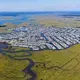 A portion of Egg Harbor Township in New Jersey, carved out of a marsh. Channels cut into the wetland give every homeowner access to the water. A 2015 study predicted that by 2050, 31 percent of Egg Harbor’s land, worth $237.5-million at the time of the report, will be inundated part of every day. Image by Alex MacLean. United States, 2019.
