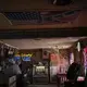 People sit in a bar decorated with an American flag and Confederate flags before noon in Meridian, Miss. Image by Wong Maye-E / The Associated Press. United States, 2020.