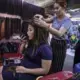A hairdresser works on a customer at the Orussey shopping complex in Phnom Penh. Image by Paula Bronstein. Cambodia, 2019.