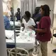 Staff members at the University Hospital of Mirebalais in central Haiti observe as pediatric oncologist Dr. Pascale Yola Gassant (not pictured), tends to Djooly Jeune, 18, who has Burkitt’s lymphoma. After his cancer failed to respond to an initial round of chemotherapy, Gassant began a new round on Tuesday, Dec. 18, at the teaching hospital. Image courtesy of Dr. Maxi Raymonville. Haiti, 2018.