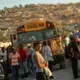 Commuters stream onto busses for an early morning commute to Port-au-Prince, the nation’s capital. An estimated 30 percent of Canaan's residents commute out of the area each day to get to work or school. Image by Allison Shelley. Haiti, 2019.
