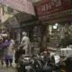In this Oct. 30, 2019, photo, people walk past drugstores where tramadol was once easily accessible in Amritsar, in the northern Indian state of Punjab. The pills were everywhere, as legitimate medication sold in pharmacies, but also illicit counterfeits hawked by itinerant peddlers and street vendors. India has twice the global average of illicit opiate consumption. Researchers estimate about 4 million Indians use heroin or other opioids, and a quarter of them live in the Punjab, India's agricultural heartland bordering Pakistan. Image by Channi Anand / AP Photo. India, 2019.