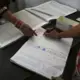 In this Thursday, Oct. 31, 2019, photo, a recovering tramadol drug user signs a register after taking her medication at a de-addiction center in Kapurthala, in the northern Indian state of Punjab. India has twice the global average of illicit opiate consumption. Researchers estimate 4 million Indians use heroin or other opioids, and a quarter of them live in the Punjab, India’s agricultural heartland bordering Pakistan, where some of the most vulnerable are driven to drugs out of desperation. Image by Channi Anand / AP Photo. India, 2019.