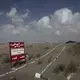 This Feb. 15, 2018, photo shows a sign with Arabic that reads, “danger mines, danger mines” on the highway from Abyan to Aden in Yemen. Image by Nariman El-Mofty. Yemen, 2018. </p>
<p>