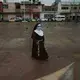 A nun wearing a mask amid the COVID-19 pandemic walks at the main square in Acatlán de Osorio, a town in Mexico where the life blood is remittances from locals who have emigrated, Thursday, June 25, 2020. Mexican migrants sent home a record $4 billion in March. After a dip in April, numbers were strong again in May. Image by Fernando Llano/AP Photo. Mexico, 2020.