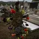 A sculpture of Jesus stands as a headstone at the cemetery in San Jeronimo Xayacatlan, a town in Mexico from where nearly a third have emigrated to New York, Thursday, June 25, 2020. On April 17, the church bells tolled for the first COVID-19 victim from the town, a young man living in New York. Four days later, another died. Image by Fernando Llano/AP Photo. Mexico, 2020.