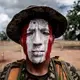 The colors of the flag of Peru painted on the face of a Peruvian army soldier. Some soldiers are Wampis members. Image by Marcio Pimenta. Peru, 2019.