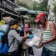 Volunteer health worker Analyn Martinez (left) and Fatima distribute relief goods to the community. Image by Xyza Bacani. Philippines, 2020.